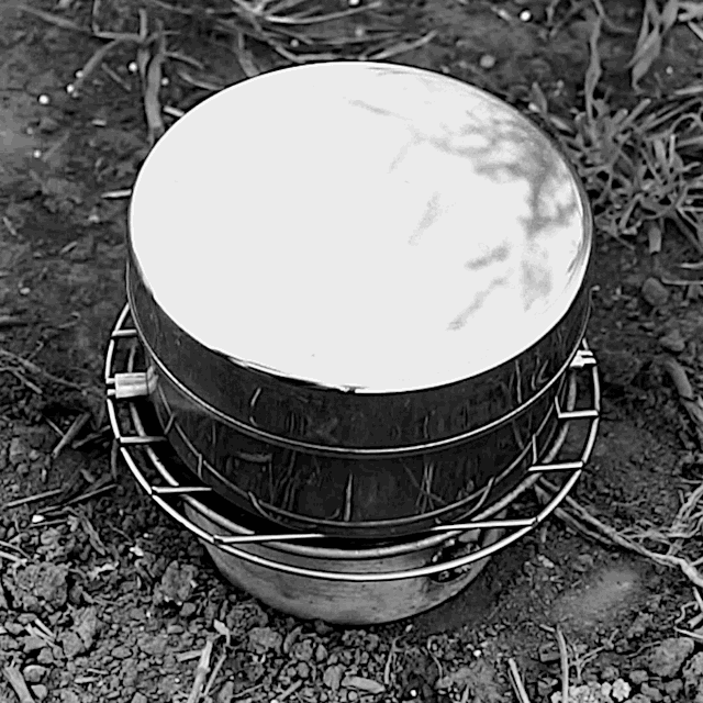 Using the Kelly Kettle: Allowing saucepan to cook over the embers